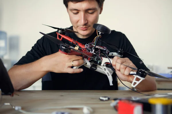 Foto do engenheiro consertar helicóptero quadrado à mesa — Fotografia de Stock