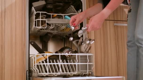 Mujer cargando utensilios de cocina en la máquina lavavajillas . — Vídeos de Stock