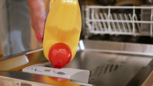 Женщина загружает посуду в посудомоечную машину . — стоковое видео