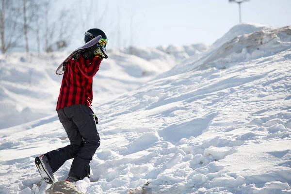 Imagem do homem com snowboard andando na encosta da montanha nevada — Fotografia de Stock