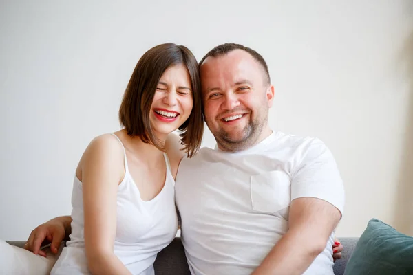 Photo of smiling married couple sitting on sofa — Stock Photo, Image