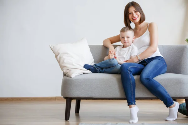 Foto de madre feliz con hijo sentado en el sofá — Foto de Stock