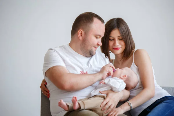 Εικόνα του ευτυχισμένο παντρεμένο ζευγάρι με νεογέννητο μωρό κάθεται στον καναπέ — Φωτογραφία Αρχείου