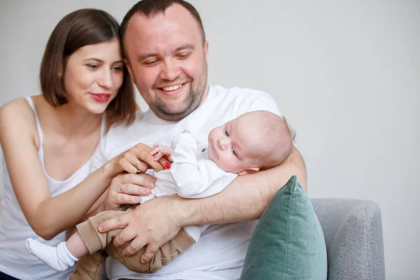 Foto de pareja casada feliz con un niño pequeño sentado en el sofá —  Fotos de Stock