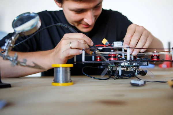 Photo of man with soldering iron repairing mechanism — Stock Photo, Image