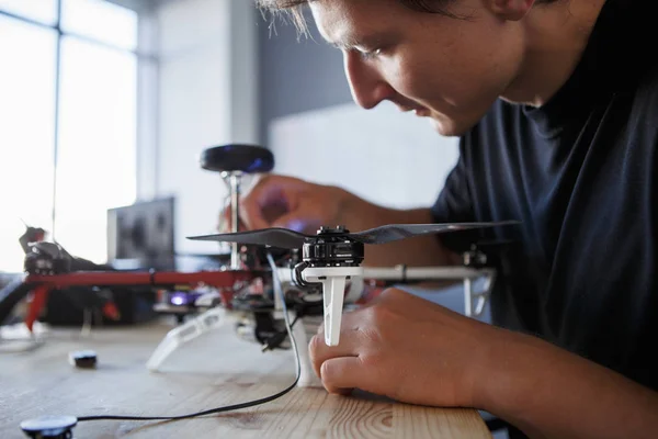 Picture of engineer fixing square copter at table — Stock Photo, Image