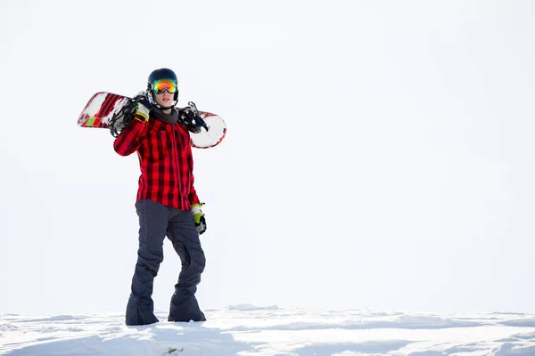 Photo of man with snowboard on shoulders standing on snowy mountainside — Stock Photo, Image