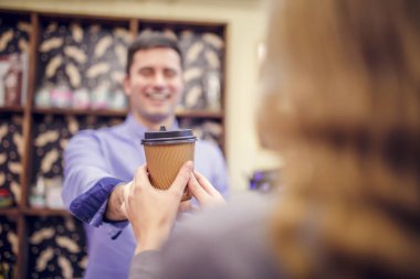 Fotoğraf bir barista adam kadına cam üzerinde arka plan bulanık germe.