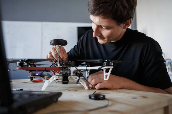 Foto do jovem limpando quadrocopter à mesa — Fotografia de Stock