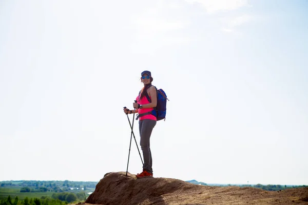 Fullängds foto av turist flicka med ryggsäck och promenadkäppar på berget — Stockfoto
