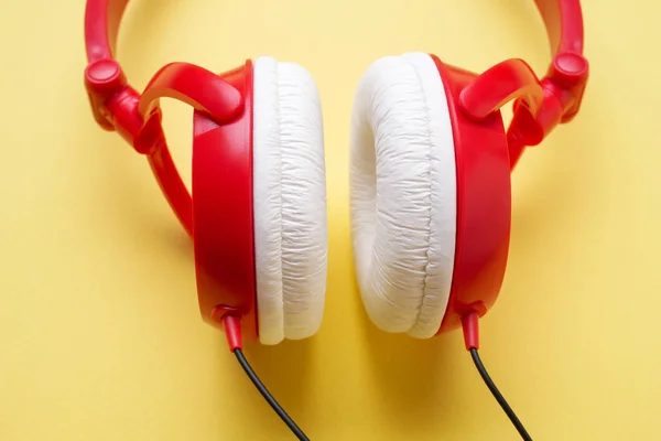 黄色背景音乐特写的红色和白色耳机照片 — 图库照片