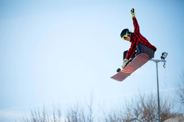 Foto de un joven atleta saltando con snowboard —  Fotos de Stock