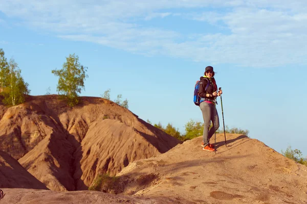 Foto de mujer turista con bastones y con mochila en la colina — Foto de Stock