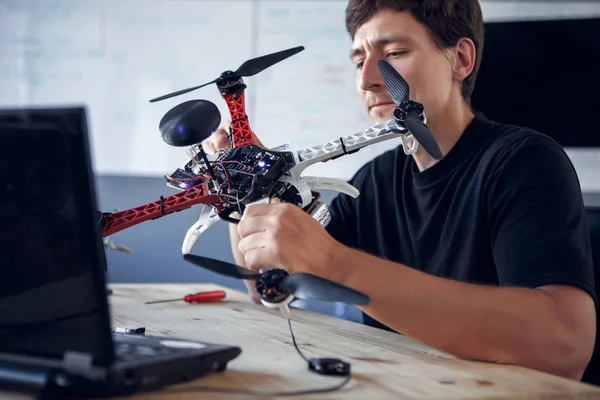 Foto del hombre que fija el helicóptero cuadrado en la mesa — Foto de Stock