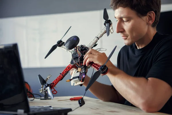 Foto do engenheiro de fixação de helicóptero e sentado à mesa com laptop — Fotografia de Stock