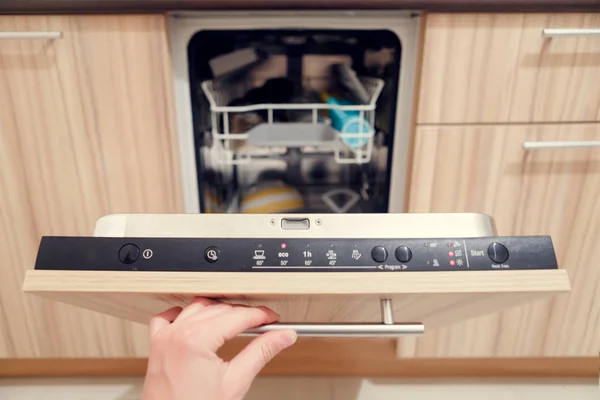 Foto de humanos mão abrindo máquina de lavar louça com pratos sujos — Fotografia de Stock