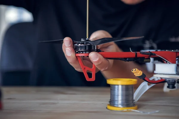 Photo of man with screwdriver cleaning quadrocopter — Stock Photo, Image