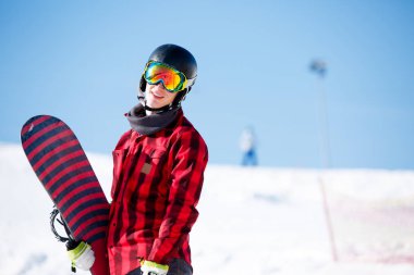Adam arka plan karlı tepelerin snowboard ile kask içinde gülümseyen fotoğraf