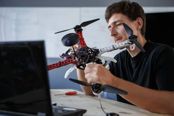 Imagem do jovem limpando quadrocopter à mesa — Fotografia de Stock