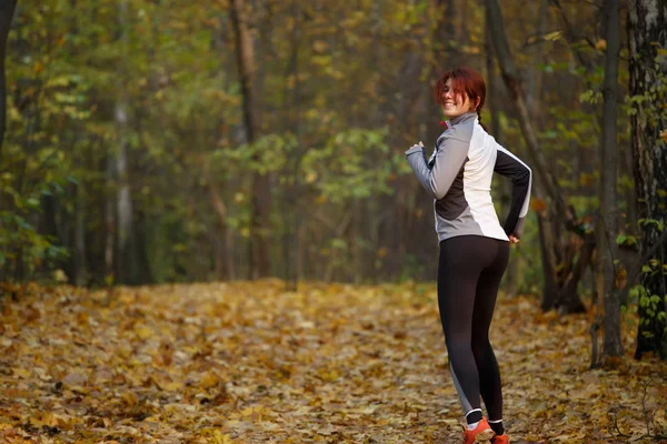 Spor giysileri üzerinde mutlu kadın görüntüsünü çalıştırmak sonbaharda — Stok fotoğraf