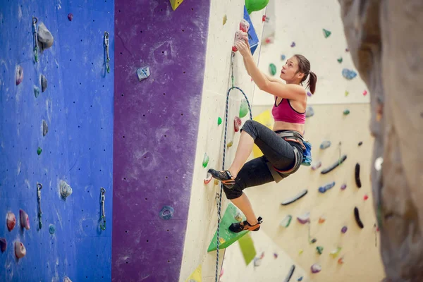 Foto des Athleten Mädchen klettert lila Wand zum Klettern — Stockfoto