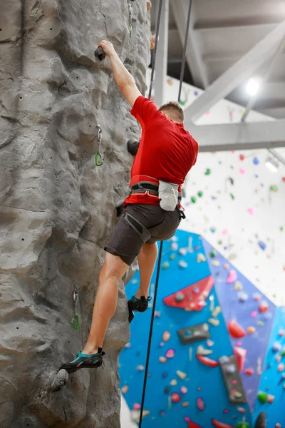 Foto vom Rücken eines Sportlers, der an einer Kletterwand trainiert — Stockfoto