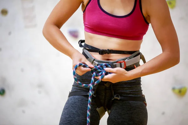 Foto de cerca del escalador deportivo con cuerda de seguridad en las manos en el gimnasio — Foto de Stock