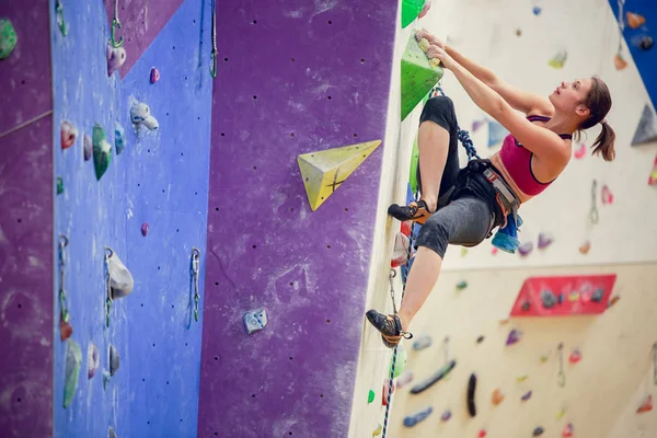 Foto von jungen Athleten Mädchen klettert lila Wand — Stockfoto