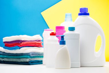 Sbottles ürünler ve beyaz masa mavi, sarı arka planda, yer yazıt için izole renkli havlu temizlik fotoğraf