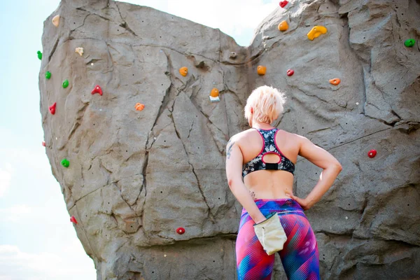 Foto vom Rücken der Sportblondine mit Tasche gegen Felsbrocken — Stockfoto