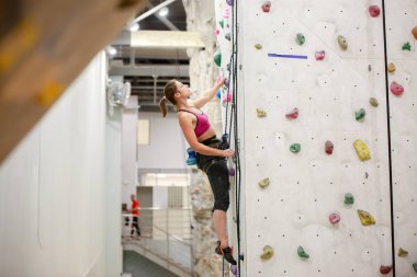 Kaya tırmanışı için egzersiz duvar üzerinde genç sporcunun fotoğraf