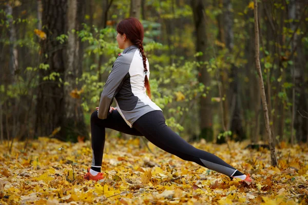 Stretching och träning. Sportig passform flicka gör sport utomhus. — Stockfoto