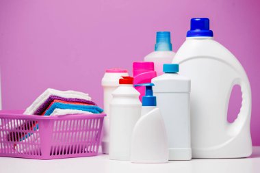 Temizlik ürünleri ve çok renkli havlu izole kırmızı, mavi arka plan üzerinde sepet içinde birkaç şişe fotoğrafı