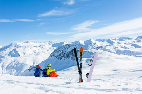 Snowboarder et skieur assis sur la neige et voir à la montagne — Photo