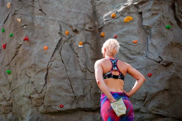 Photo from back of sporty woman climber with bag of soap against rock boulder — Stock Photo, Image