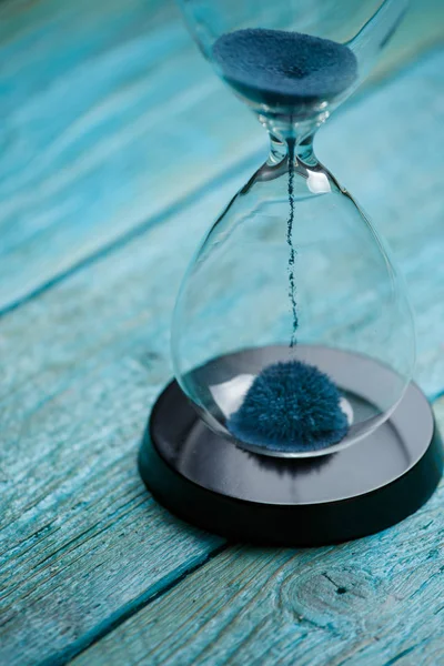 Foto av timglas med blå sand på trä bakgrund, — Stockfoto