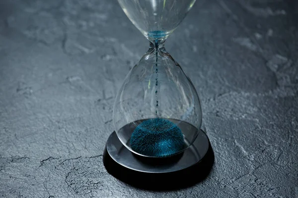 Foto von Glas Sanduhr mit blauem Sand auf schwarzem Stein Hintergrund — Stockfoto