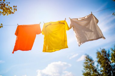 Üç T-shirt halat mavi gökyüzü arka plan asılı fotoğrafı
