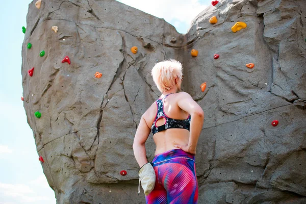 Φωτογραφία από πίσω σπορ κορίτσι ορειβάτης με τσάντα του σαπουνιού εναντίον ροκ ογκόλιθος — Φωτογραφία Αρχείου