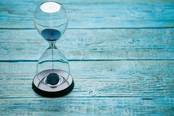 Foto de reloj de arena azul sobre fondo de madera , —  Fotos de Stock