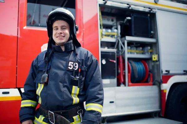 Foto do bombeiro em frente ao carro de bombeiros — Fotografia de Stock