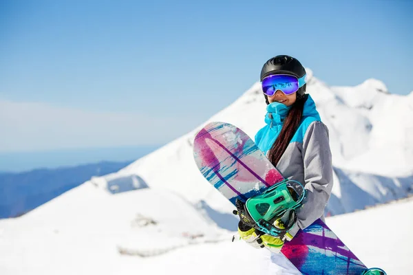 Foto de mujer haciendo senderismo casco con snowboard sobre fondo de montañas de nieve — Foto de Stock