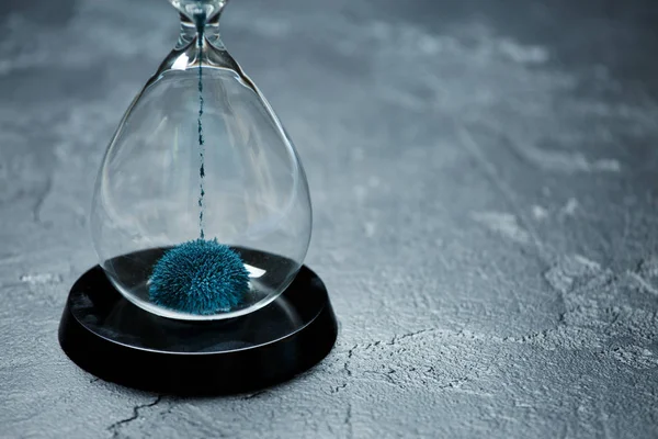 Bild av timglas med blå sand på svart sten bakgrund, — Stockfoto