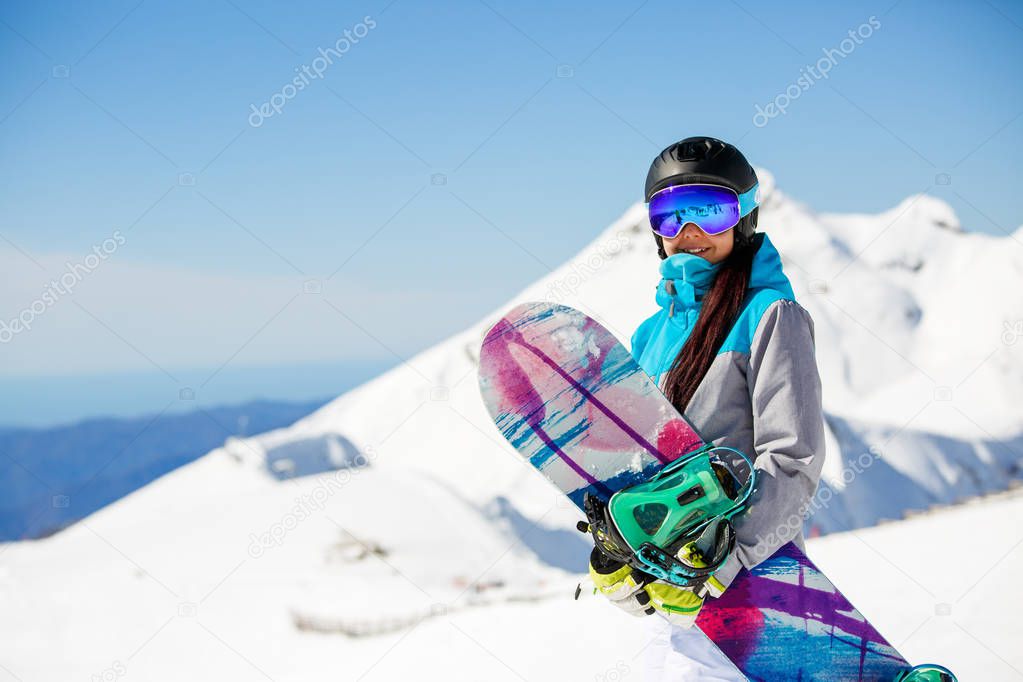 Photo of woman hiking helmet with snowboard on snow mountains background