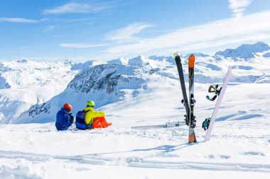 snowboard ve kar ve dağları görmek skiier oturma