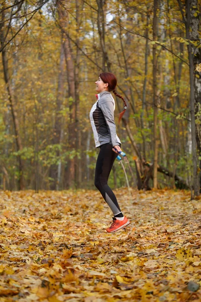 In voller Länge Bild der jungen Brünette springen mit Seil im Herbst Wald — Stockfoto