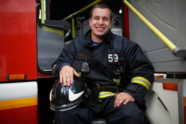 Photo of happy fireman looking at camera in fire truck