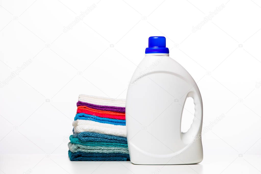 Photo of bottle of cleaning products and multi-colored cloths