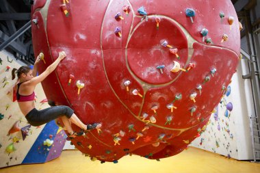 Fotoğraf genç sporcu kadın kırmızı top spor salonunda tırmanma tarafındaki