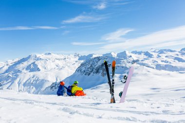 snowboard ve kar ve dağları görmek skiier oturma